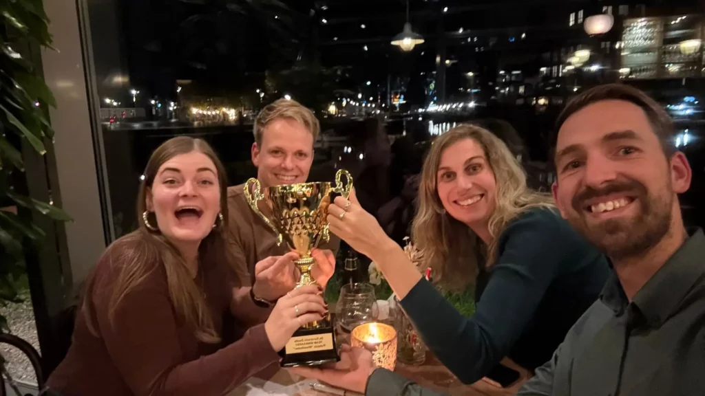 Winnend team juicht met de beker na een pubquiz van Quiz van Roos