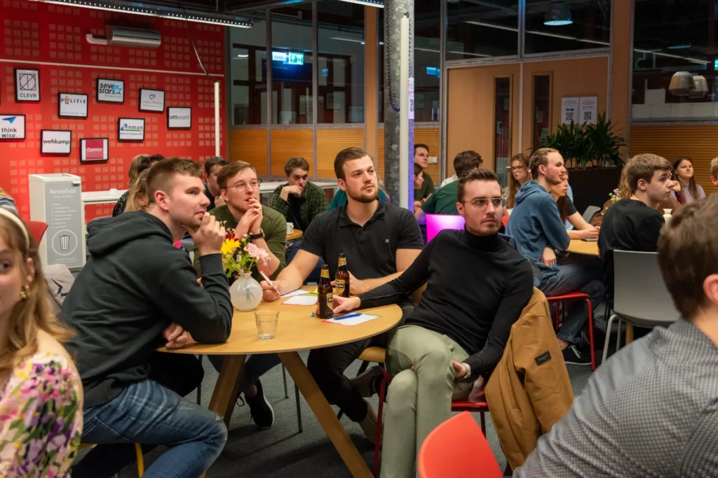 Collega's aan tafel tijdens een pubquiz als bedrijfsuitje